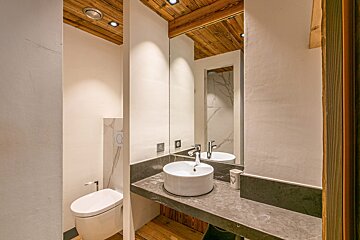 A bathroom with a toilet a sink and a mirror