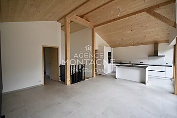 Modern open-concept room with a vaulted wooden ceiling, tiled floors, white kitchen cabinets, and a central island.