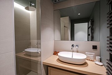 A bathroom with a sink a mirror and a shower