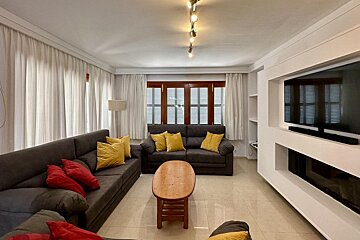 A dining room table with a bowl of oranges on it