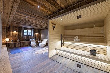 A wooden sauna with a bucket of water on the shelf