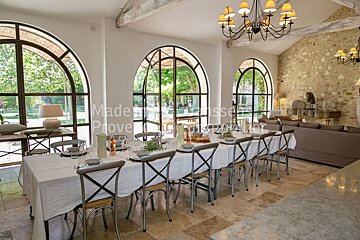 A dining room with a long table and chairs and the words made in provence on the bottom