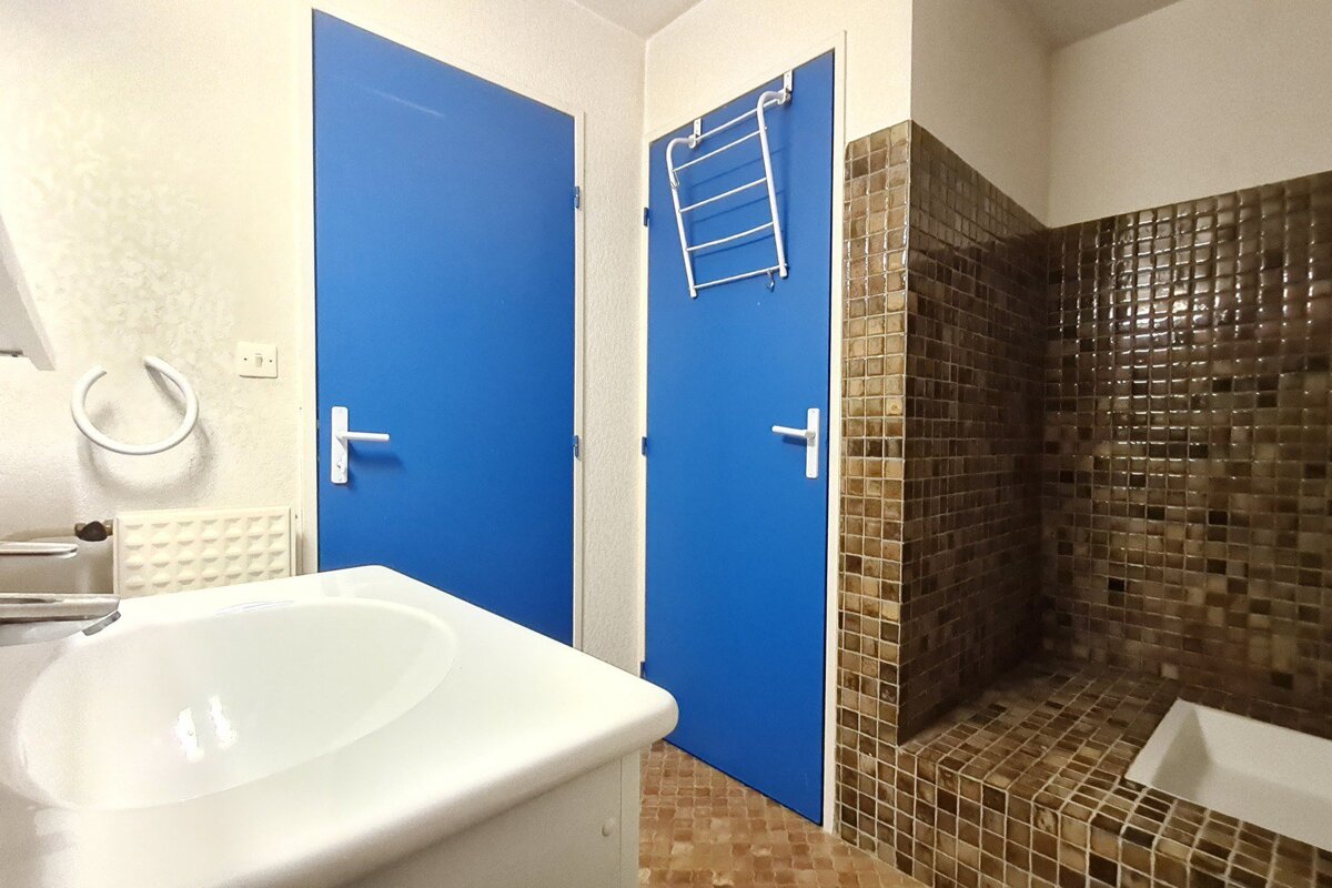 A bathroom with blue doors and a white sink