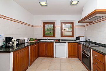 A kitchen with wooden cabinets and a white dishwasher