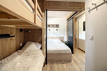 A bedroom with bunk beds and a sliding glass door