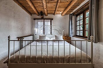 A small bedroom with a bed and a window