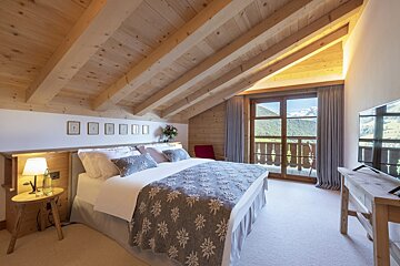 A bedroom with a large bed and a television