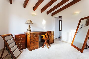 A room with a desk and chair and a large mirror