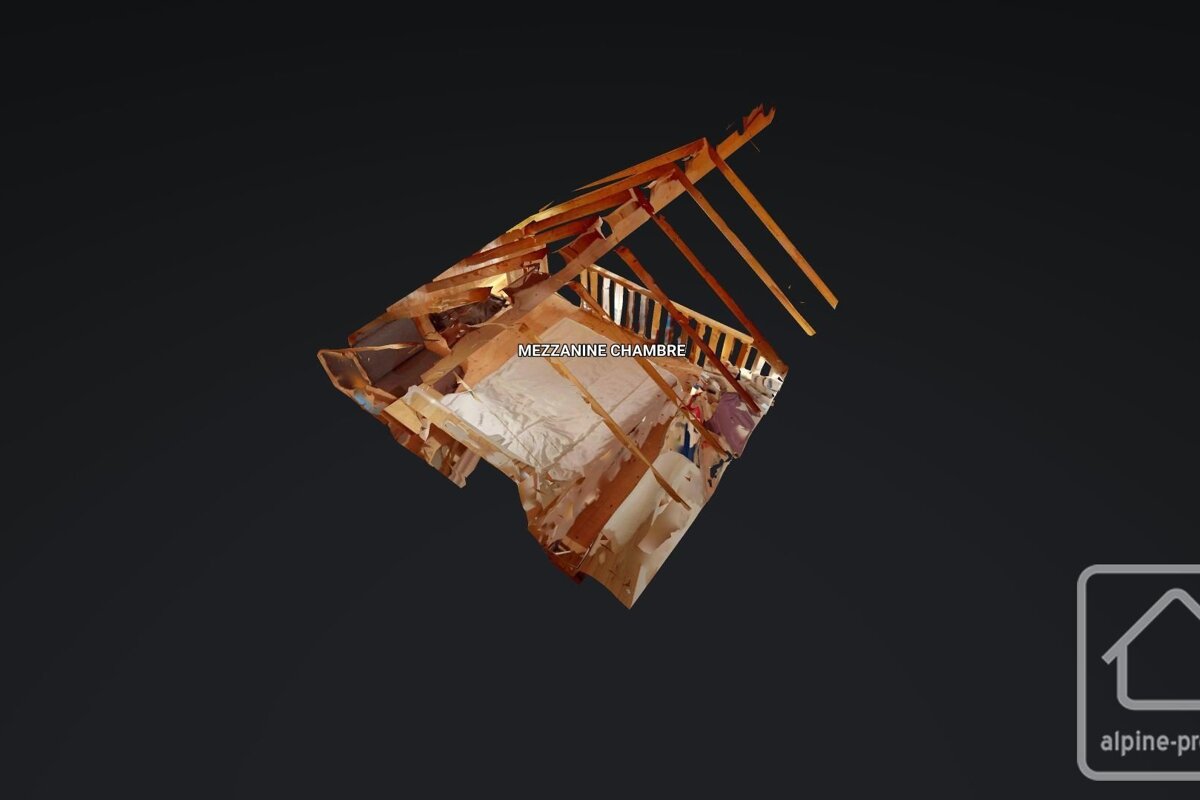 A 3D model of a deconstructed 'MEZZANINE CHAMBRE' (bedroom) with exposed wooden framework and a bed, on a dark background with a logo.