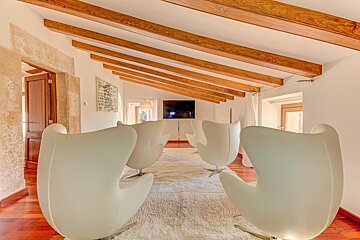 A living room with white chairs and a flat screen tv