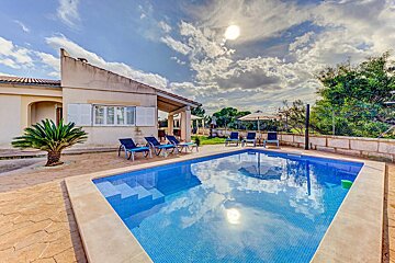 A house with a large swimming pool in front of it