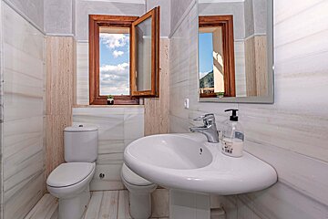 A bathroom with a toilet a sink and a mirror