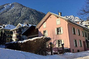 A pink house with a mountain in the background
