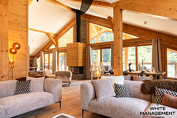 A bunk bed with white sheets and a wooden ladder