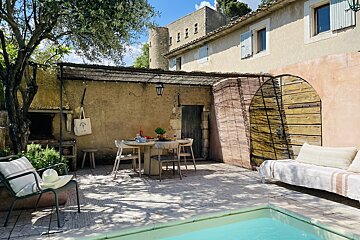 A patio with a table and chairs next to a pool