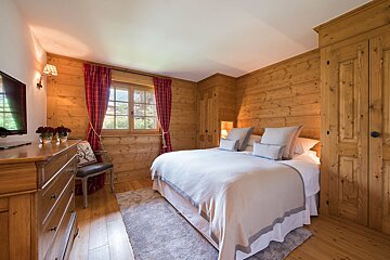 A bedroom with a large bed and a flat screen tv
