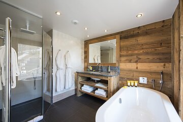 A bathroom with a bathtub a sink and a mirror