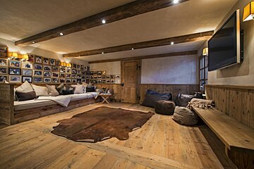 A living room with a rug on the floor and pictures on the wall
