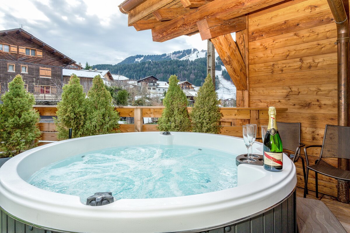 A bottle of champagne sits next to a hot tub