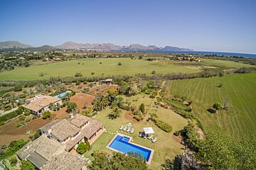 An aerial view of a large house with a swimming pool
