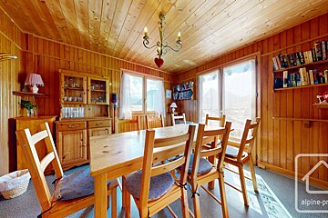 A dining room with a table and chairs and a sign that says alpine-pro