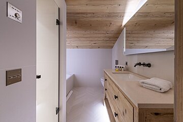 A bathroom with a wooden ceiling and a sink