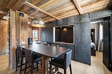 A kitchen with a table and chairs and a coffee maker
