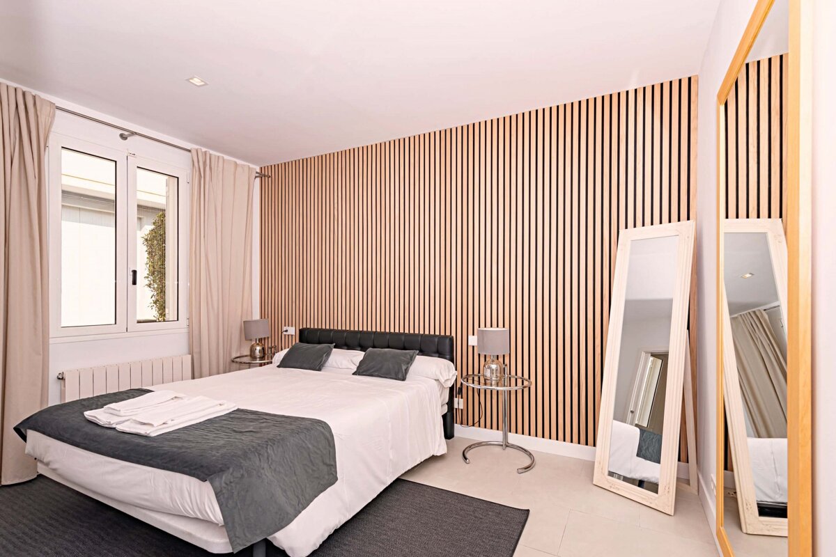 A bedroom with a large bed and two mirrors