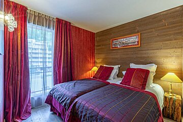 A hotel room with two beds and a picture on the wall