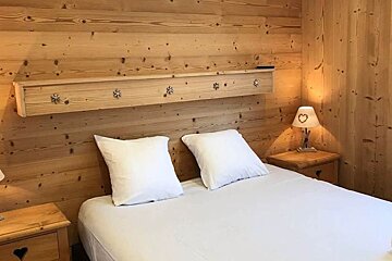 A bedroom with a bed and two lamps with hearts on them