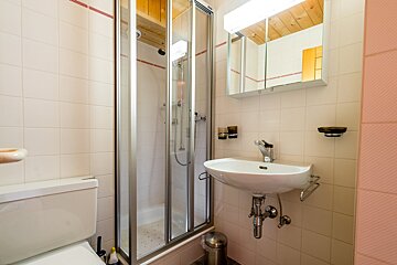 A bathroom with a toilet a sink and a shower