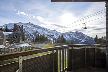 A balcony with a view of mountains and a ski lift
