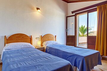 A bedroom with two twin beds and a sliding glass door