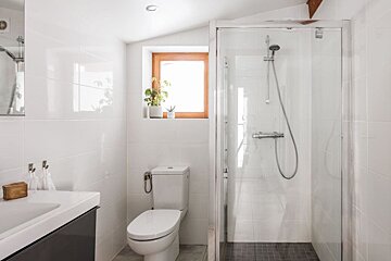 A bathroom with a toilet and a walk in shower