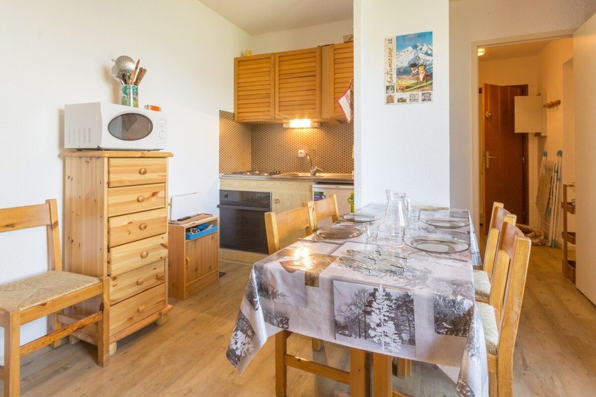 A kitchen with a table and chairs and a poster on the wall that says montagne