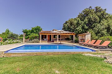 A house with a large swimming pool in front of it