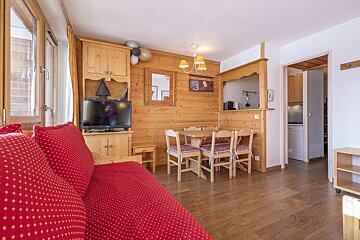 A living room with a red couch and a flat screen tv