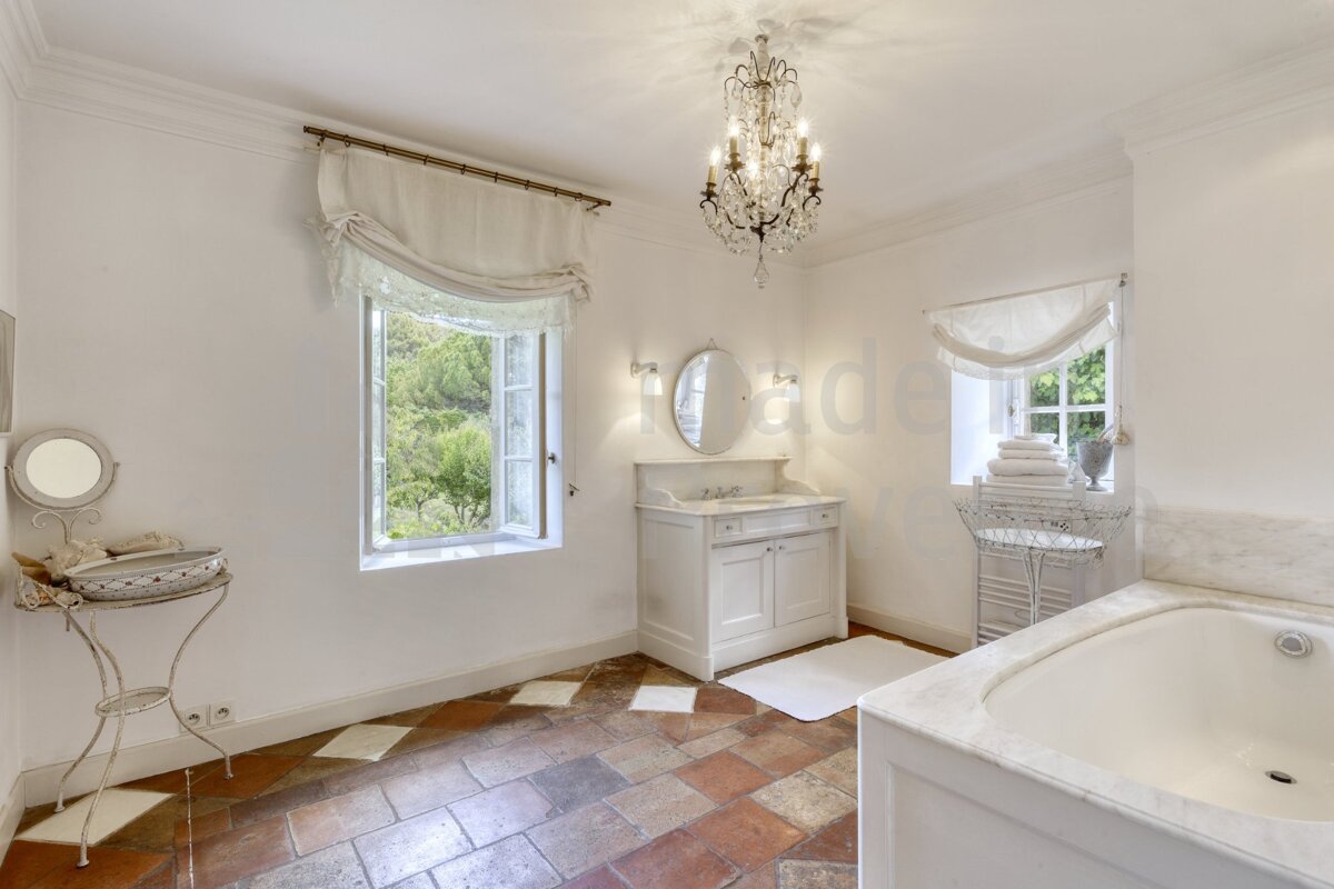 A bathroom with a sink a mirror and a chandelier
