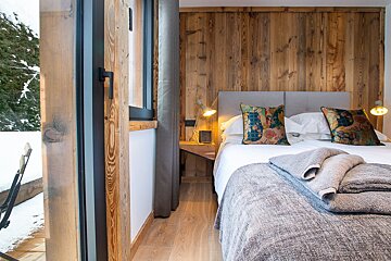 A bedroom with a bed and a sliding glass door