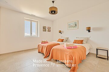 A bedroom with two beds made in provence by janssens immobilier