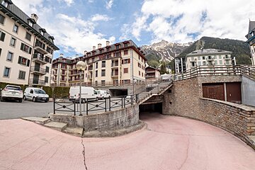 White vans parked in front of a building with a mountain in the background