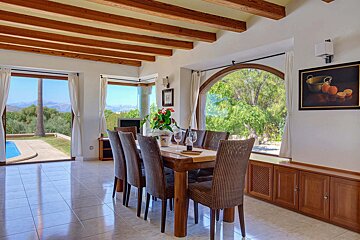 A dining room with a table and chairs and a picture on the wall