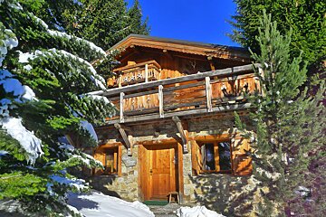 A wooden house with a balcony and a sign that says ' a ' on it
