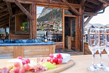 A bottle of wine sits on a table next to a hot tub