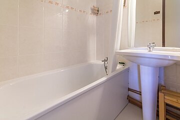 A bathroom with a bathtub and a sink with numbers on the wall