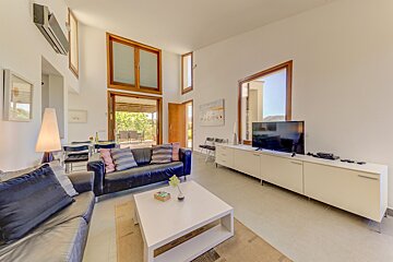 A living room with a black couch and a flat screen tv