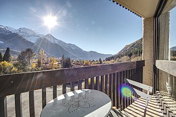A balcony with a view of mountains and trees