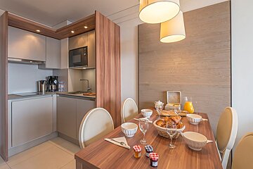 A table with a basket of bread and jam on it