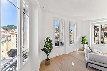 A living room with a couch and two potted plants