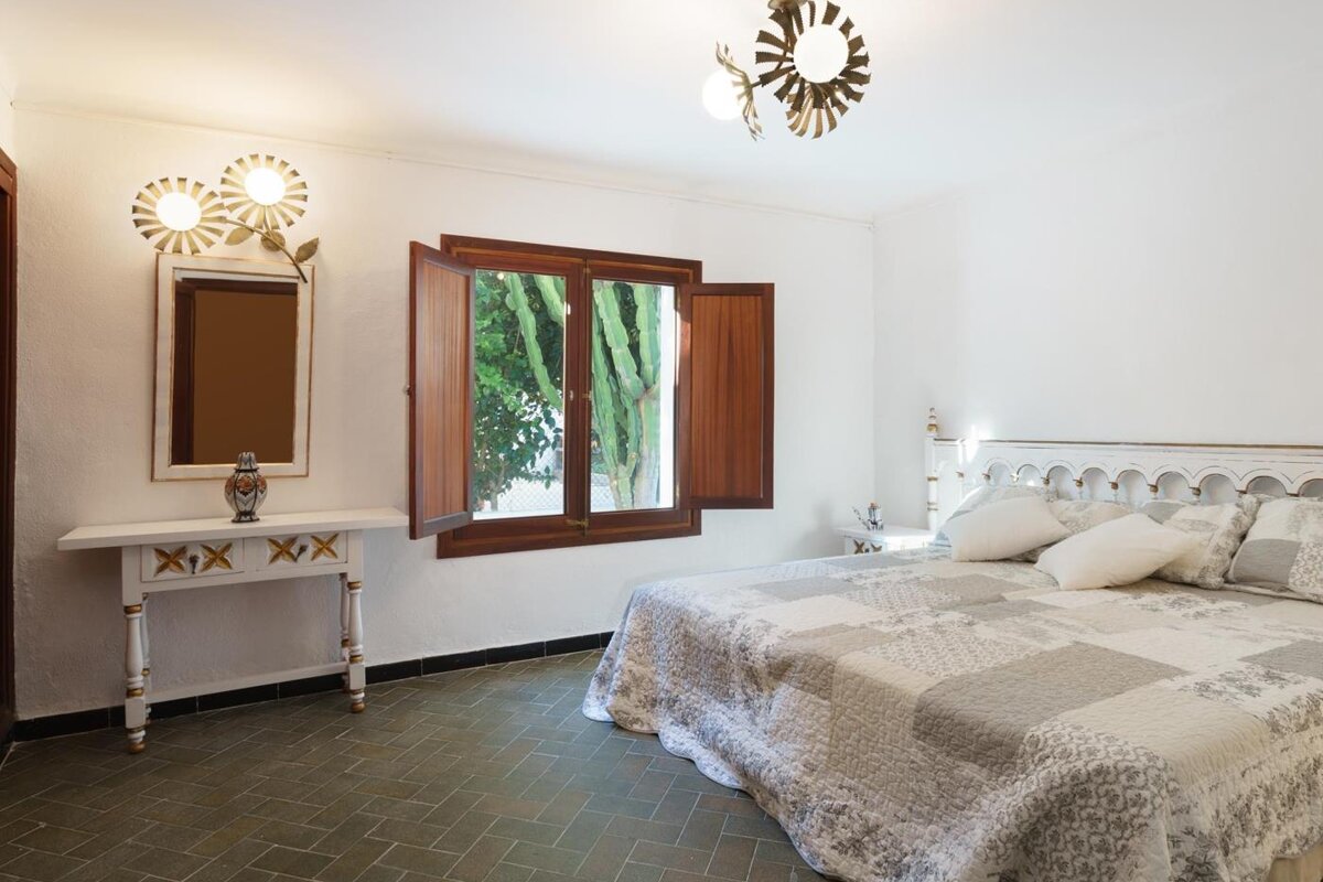 A bedroom with a large bed and a mirror